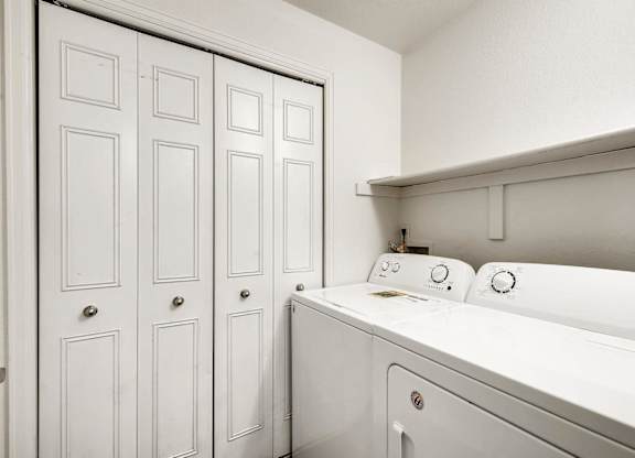 A white washing machine in a laundry room.