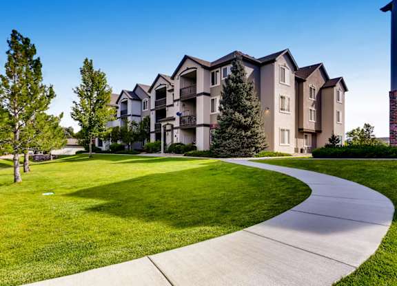 A residential building with a green lawn in front.