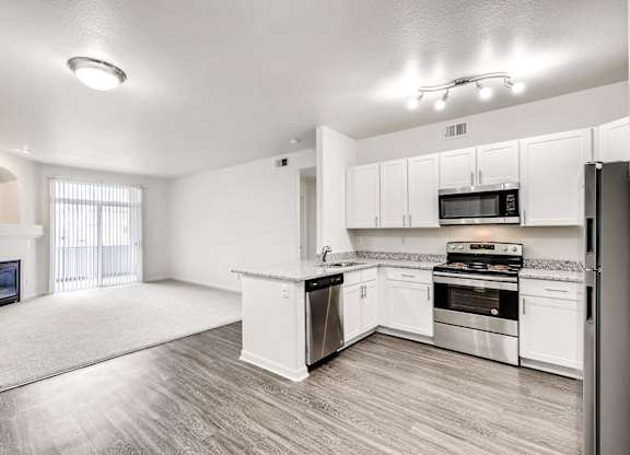 A spacious kitchen with white cabinets and stainless steel appliances.