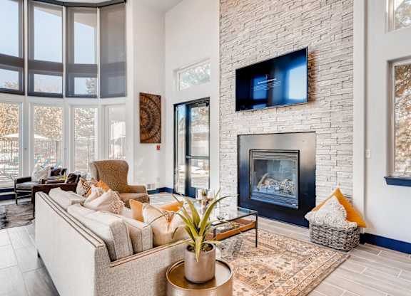 A living room with a fireplace and a flat screen TV mounted on the wall.