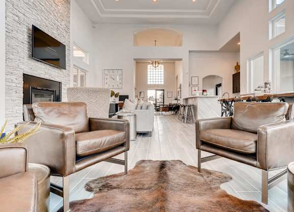 A living room with a white brick fireplace and a brown cowhide rug.