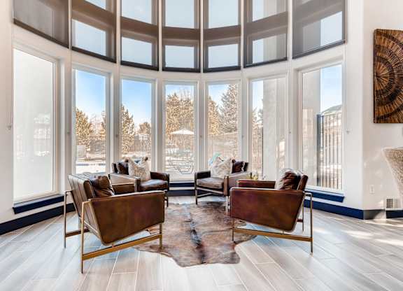 A living room with a large window and a view of trees.