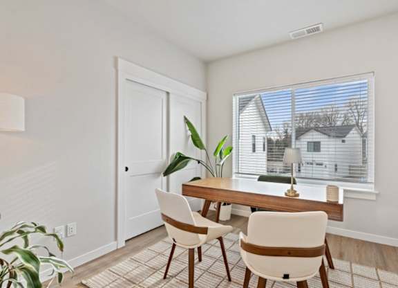 A dining room with a table and chairs.