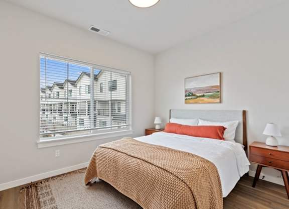 A bedroom with a large bed and a painting on the wall.
