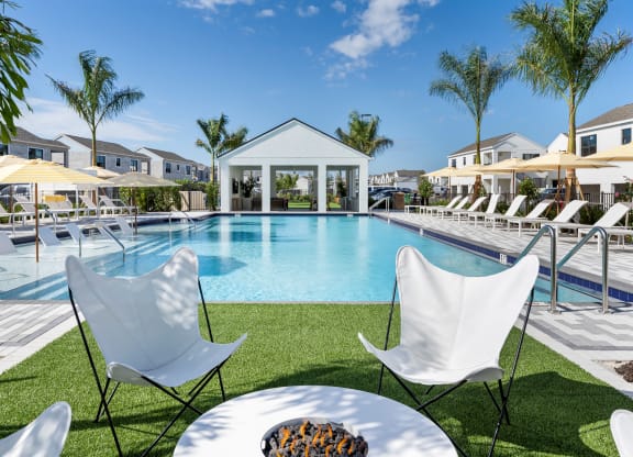 Altair by Soltura a swimming pool with chairs and umbrellas in front of a house