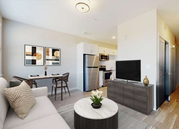 A modern living room with a white sofa, a grey coffee table, and a flat screen TV.