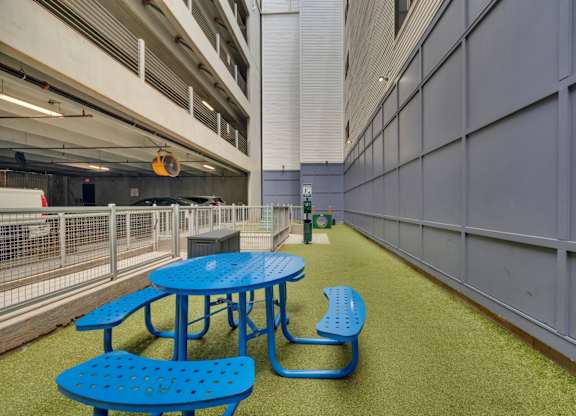 A blue picnic table and bench are in a parking garage.