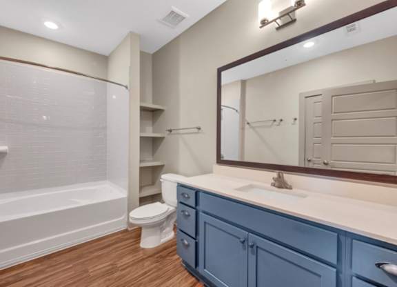 A bathroom with blue cabinets and a white sink.