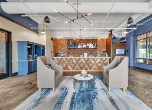 A modern office lobby with a blue carpet and a wooden patterned wall.
