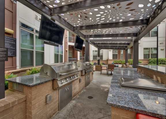 A patio with a grill and a flat screen TV.