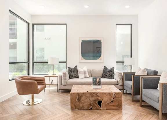 Alvera at the Meadows  living room with a wooden coffee table and a grey sofa.