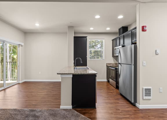 an empty kitchen with stainless steel appliances and a counter top
