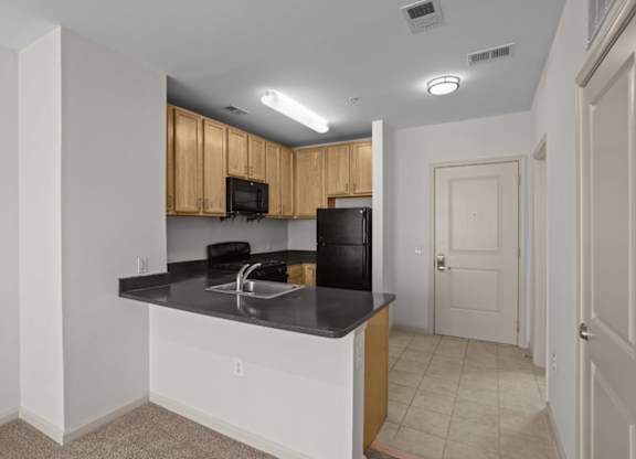 A kitchen with black countertops and white cabinets.