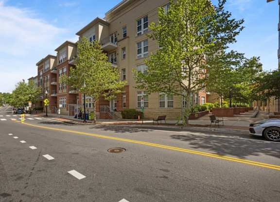 A street view of a residential area with apartment buildings on the side.