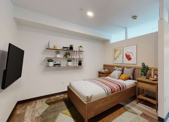 A bedroom with a bed, a TV, and a window.