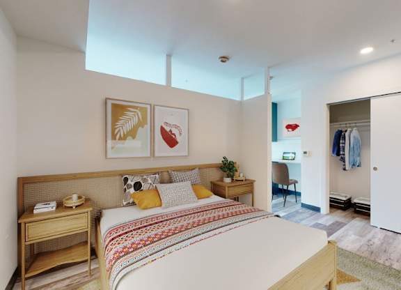A bedroom with a bed, nightstand, and chair.