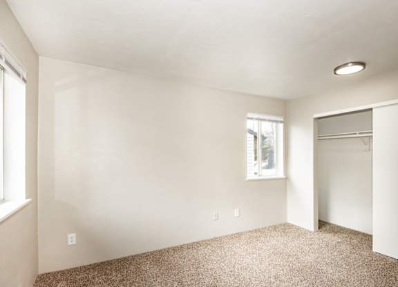 A room with a carpeted floor and a window.
