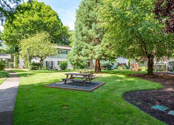 A picnic table sits in the middle of a grassy area.