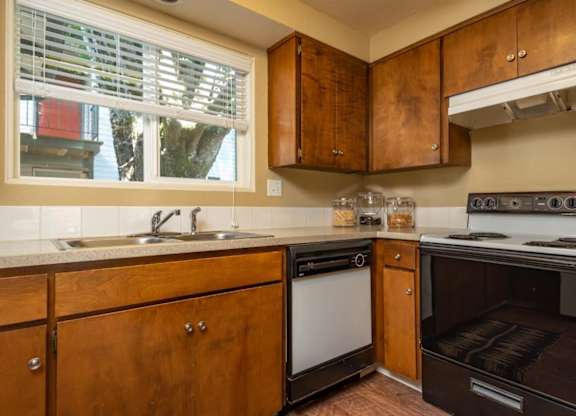 A kitchen with wooden cabinets and a stove top oven.