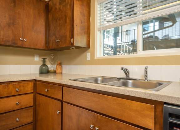A kitchen with wooden cabinets and a stainless steel sink.