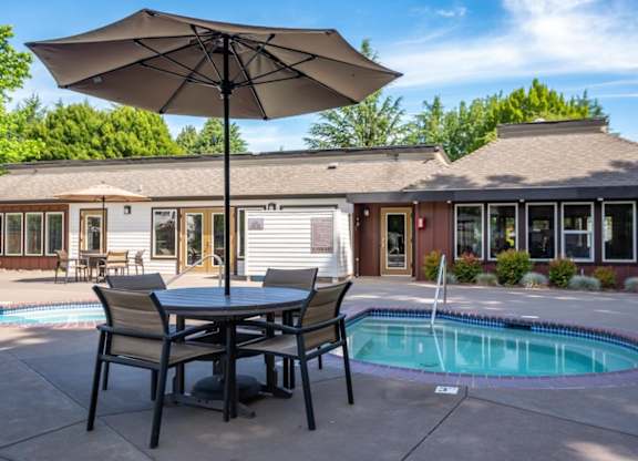 A patio with a table and chairs and an umbrella is shown.