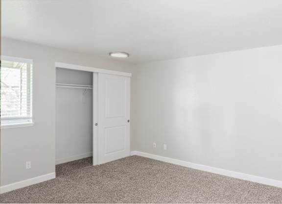 A room with a white door and carpeted floor.