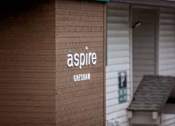 A sign on a building that says "aspire Gresham".