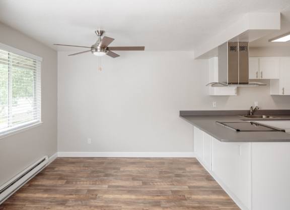 A room with a ceiling fan and a window with blinds.