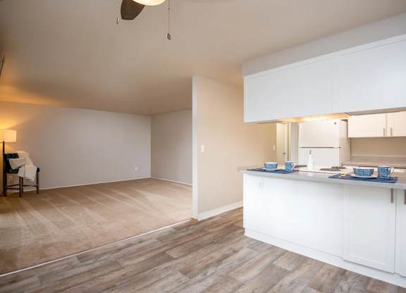 A kitchen with a dining table and chairs in the living room.