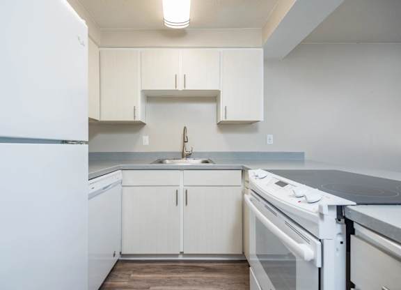 A kitchen with white appliances and cabinets.