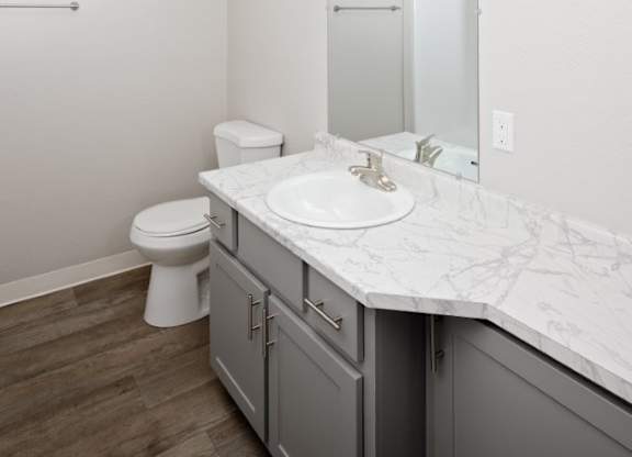 A bathroom with a marble countertop and a white toilet.