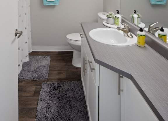 A bathroom with a white toilet, sink, and mirror.