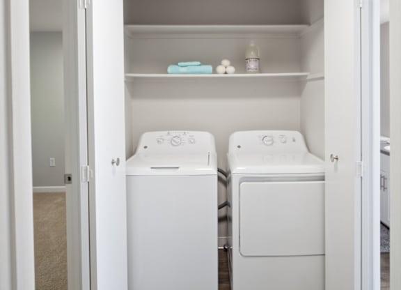 A white laundry room with a washer and dryer.