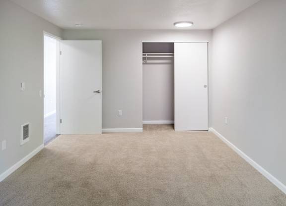 A room with a carpeted floor and a white door.