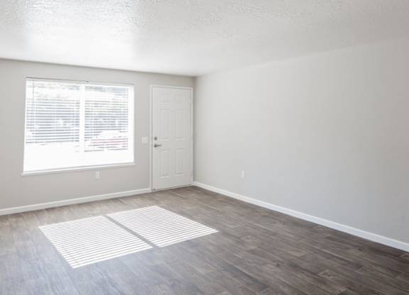A room with a white door and a window with blinds.