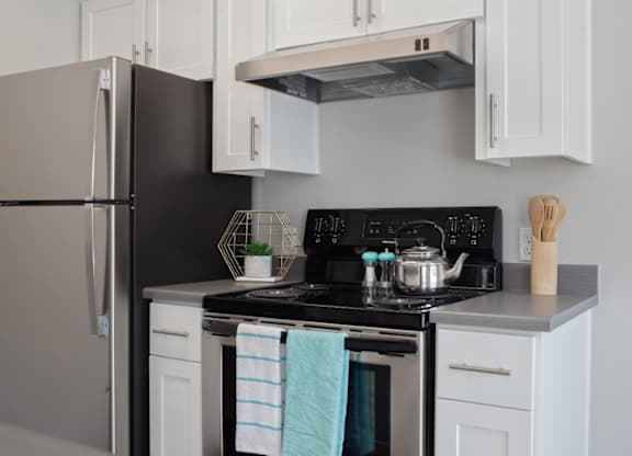 A kitchen with a black stove top and white cabinets.