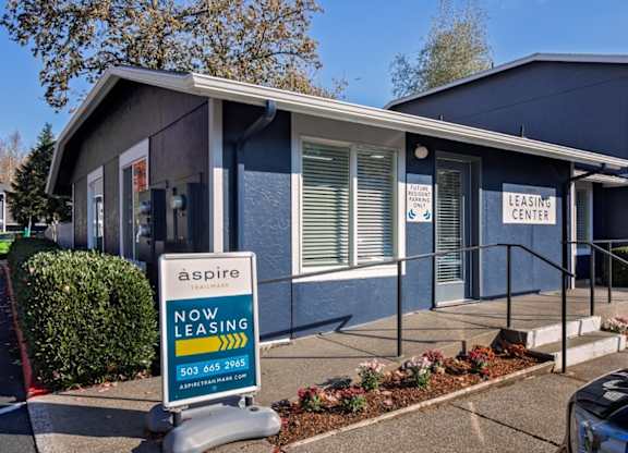 A blue building with a sign that says "aspire leasing center".