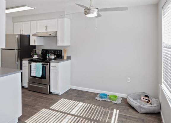A kitchen with a black stove top oven and white cabinets.