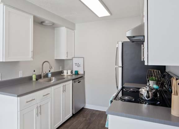 A kitchen with white cabinets and a stainless steel counter.