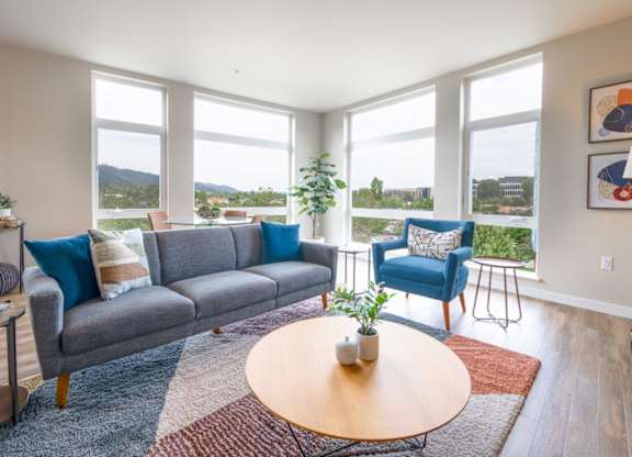 A living room with a grey couch, blue chair, and a wooden coffee table.
