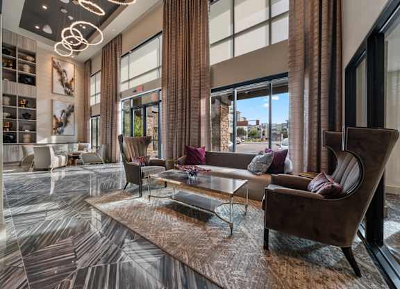 A living room with a brown sofa and a glass coffee table.