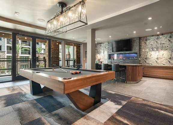 A game room with a pool table and tv