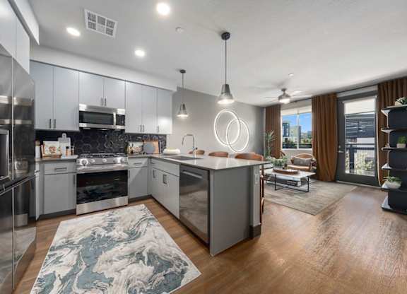 A modern kitchen with a large island and stainless steel appliances.