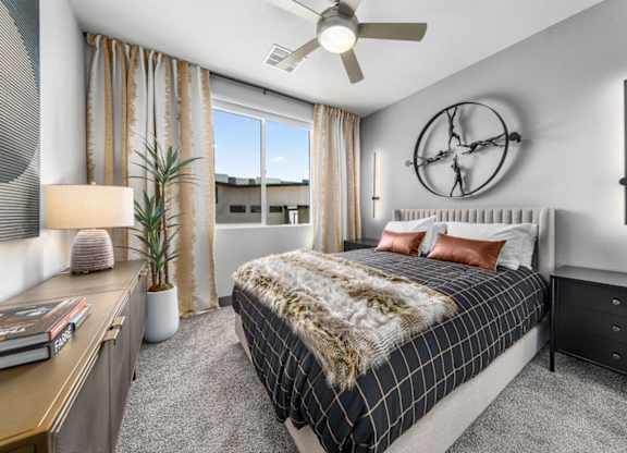 A bedroom with a large bed and a ceiling fan.