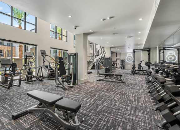 A spacious gym with a variety of equipment including treadmills, weights, and exercise machines.