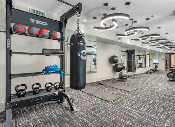 A gym with a punching bag, weights, and exercise equipment.