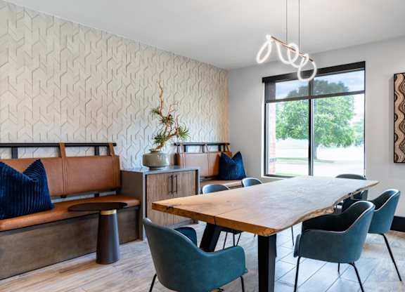 A dining room with a wooden table and blue chairs.