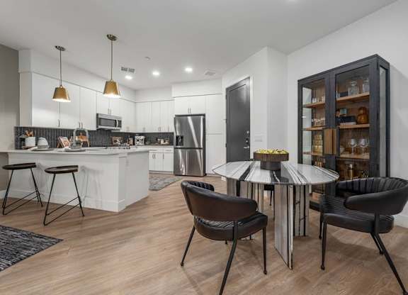 A modern kitchen with a dining table and chairs.