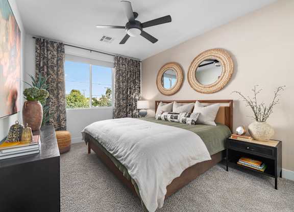 A bedroom with a bed, nightstand, and a ceiling fan.