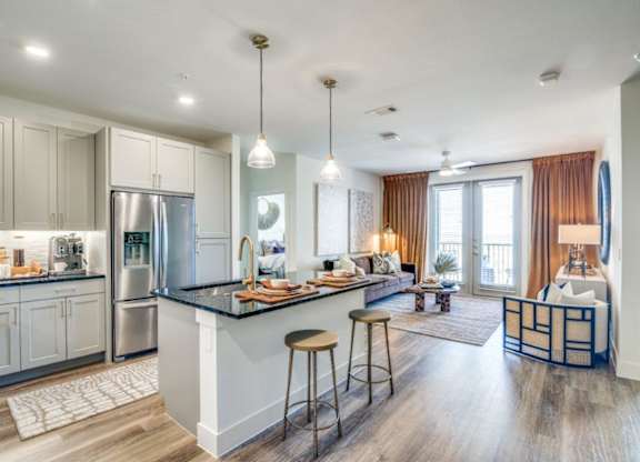 A modern kitchen with a bar and a living room area.